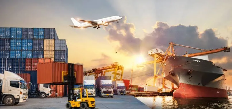 Container port, cargo ship and freight vehicles at sunset
